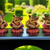 Handmade multicolor burnt clay Ganesha musician figurines set of four, displayed on a black surface with a garden background.