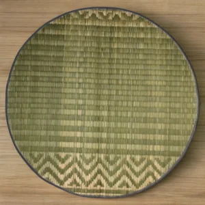 Top view of a handmade 2ft round river grass mat with traditional pattern and black edge on wooden floor
