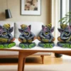 Handmade multicolor burnt clay Ganesha musician figurines set of four with green caps, placed on a wooden table in a warm indoor setting with candles, wall art, and decorative baskets.