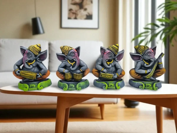 Handmade multicolor burnt clay Ganesha musician figurines set of four with green caps, placed on a wooden table in a warm indoor setting with candles, wall art, and decorative baskets.