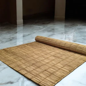 Rolled handmade river grass mat on a glossy marble floor in a minimalist indoor setting — natural, eco-friendly, and 3x7 ft in size.