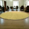 4ft round river grass (Madurkathi) rug placed in a spacious living room with wooden flooring and natural lighting