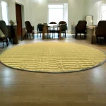 4ft round river grass (Madurkathi) rug placed in a spacious living room with wooden flooring and natural lighting
