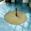 4ft round Madurkathi river grass mat placed on a blue marble floor with a decorative vase centerpiece in natural light