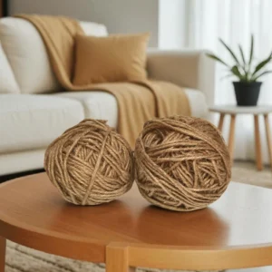Two large balls of thick 5mm natural jute twine placed on a round wooden table in a cozy living room setting.