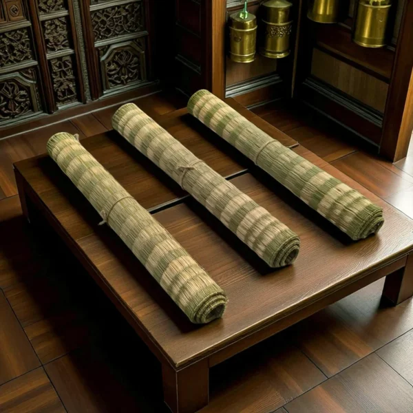 Three rolled Kush Grass (Darbha Grass) mats placed on a wooden platform in a traditional pooja room setting.