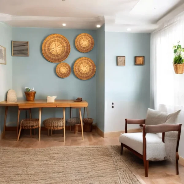 Four handwoven bamboo wall baskets arranged on a light blue wall in a minimalist room with wooden furniture and soft natural light