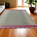 Handwoven Madurkathi grass mat with ethnic border placed in a modern indoor living room