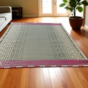 Handwoven Madurkathi grass mat with ethnic border placed in a modern indoor living room