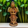 Handmade burnt clay Maa Durga statue placed on a white surface with green leafy plants in the background, showcasing intricate terracotta craftsmanship.