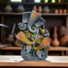 Handmade burnt clay Lord Ganesha statue in black terracotta finish with painted details, placed on a wooden surface in an artisan workshop.