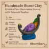 Handmade burnt clay Krishna face decorative statue with peacock feather, placed on a traditional catalog background with specifications and Bhumikart branding.