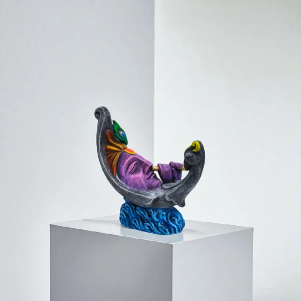 Handmade colorful clay Krishna idol resting on a crescent moon, playing flute — artistic terracotta sculpture made in India.