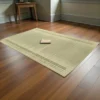 Handmade natural reed grass mat placed on a wooden floor with a folded cloth on top – eco-friendly Madurkathi sleeping and yoga mat.