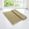 Natural green handwoven Madurkathi mat half rolled near window – eco-friendly sleeping and yoga mat by Bhumikart