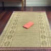 Extra large handwoven Madurkathi korai grass floor mat with traditional woven border placed on wooden floor for indoor decoration and sleeping