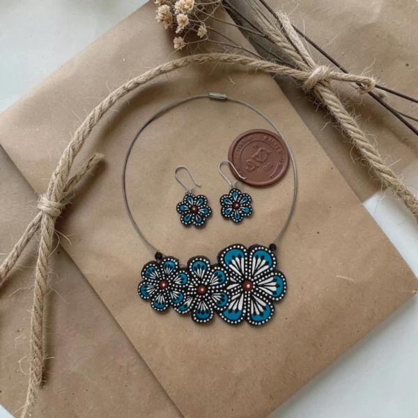 Handmade blue floral clay jewelry set with necklace and matching earrings on eco friendly kraft packaging
