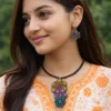 indian woman wearing handmade colorful terracotta floral necklace and earrings with traditional kurta close up