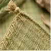 Close-up of a handmade natural reed grass mat corner showing intricate handwoven Korai grass fibers, reinforced braided edge, and decorative tassel crafted by Indian artisans.