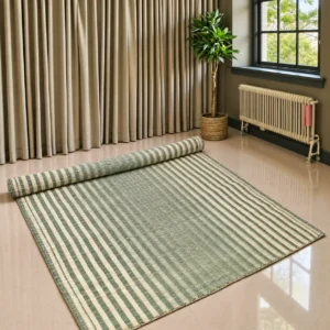 “Handmade natural grass mat with green and cream stripes, fully spread on a polished floor with one end rolled up. The large woven mat has a natural textured surface and hand-finished edges in a bright modern room with curtains, an indoor plant and a window.”